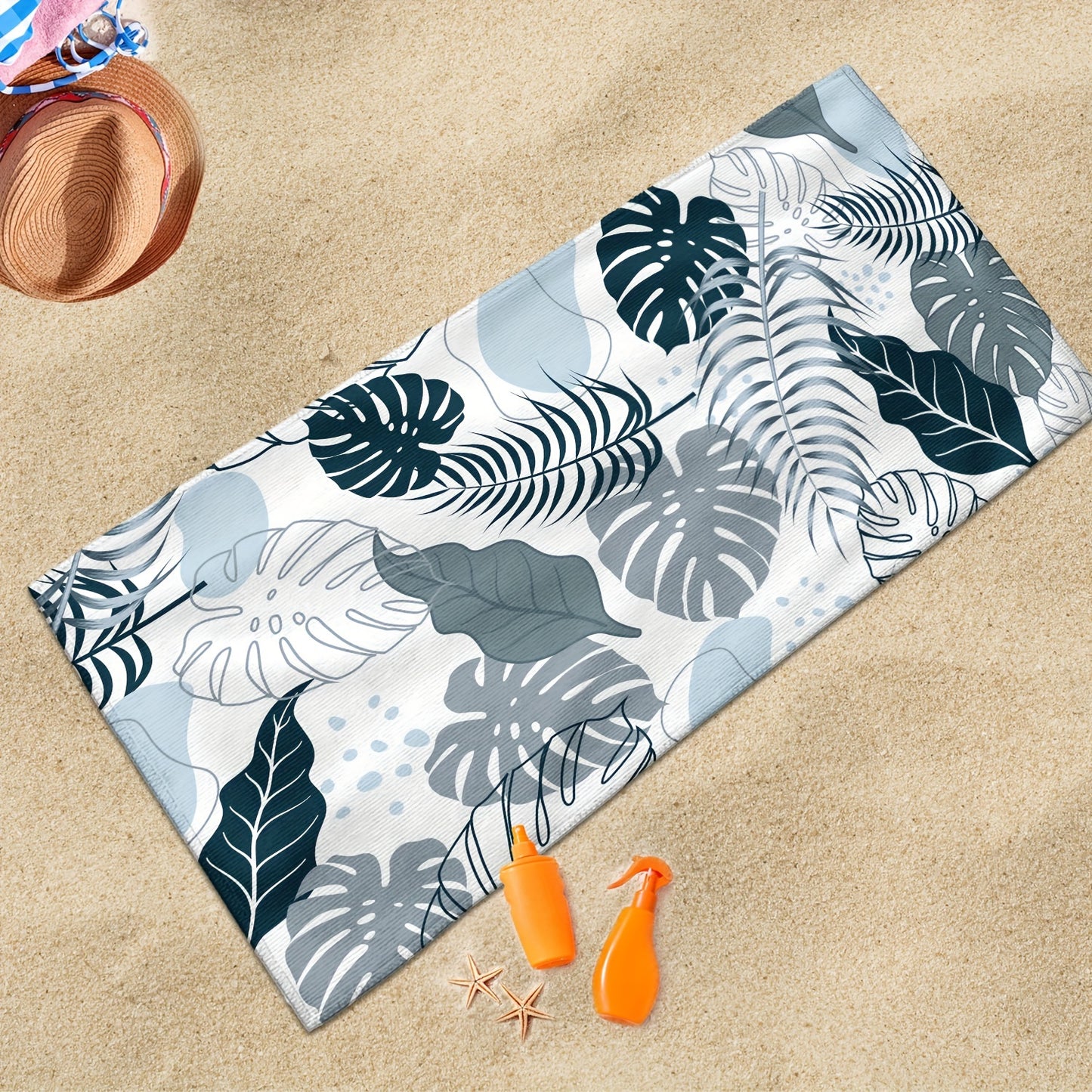 Tropical leaves in different shades of blue on beach bath towel